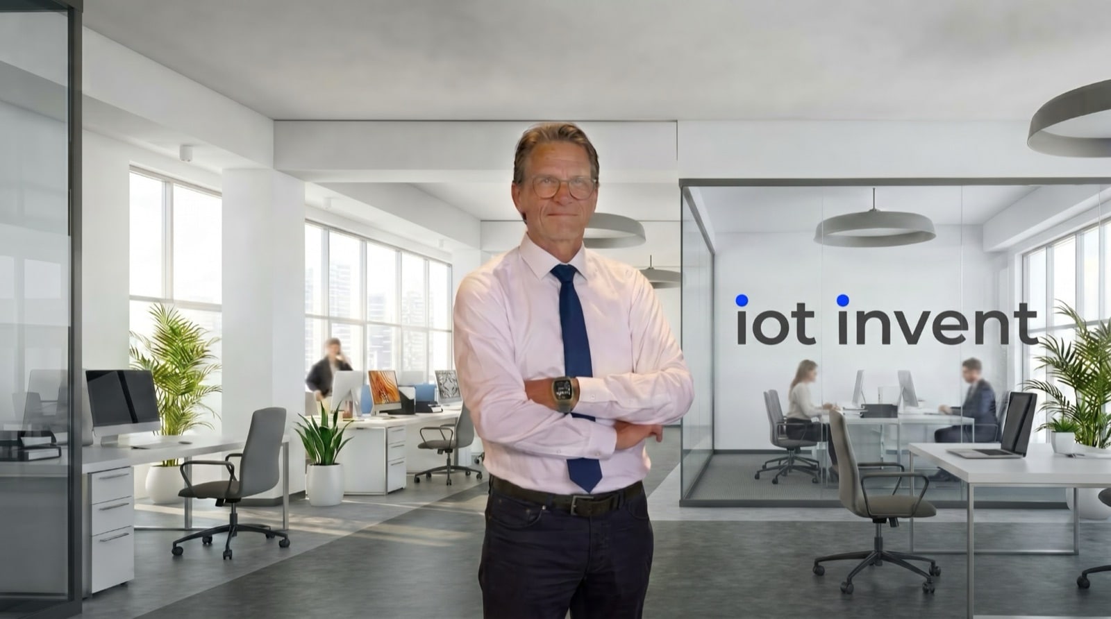Martin Dobler, CEO von iot invent, mit verschränkten Armen in einem hellen Büro, im Hintergrund der Schriftzug iot invent